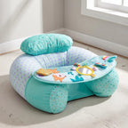 A baby activity seat in mint green and lavender with a patterned fabric, featuring a built-in headrest, a tray with colorful animal toys, and a small mirror, shown in a brightly lit room corner.