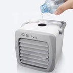 Small portable air conditioner with water being poured into it on a white background