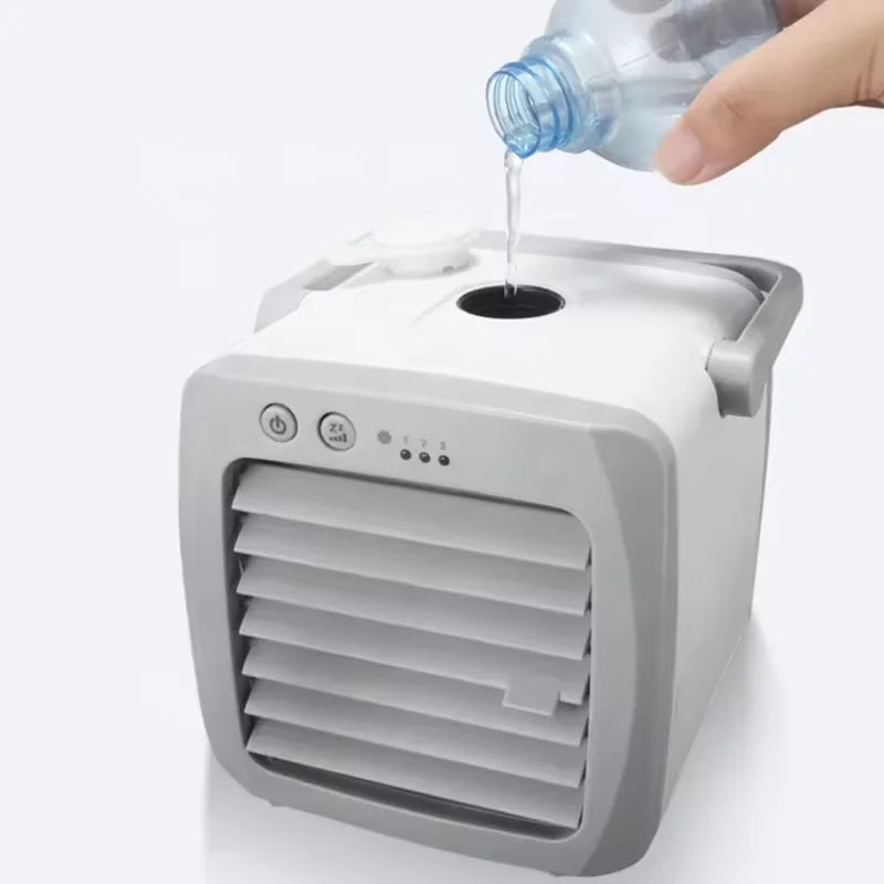 Small portable air conditioner with water being poured into it on a white background