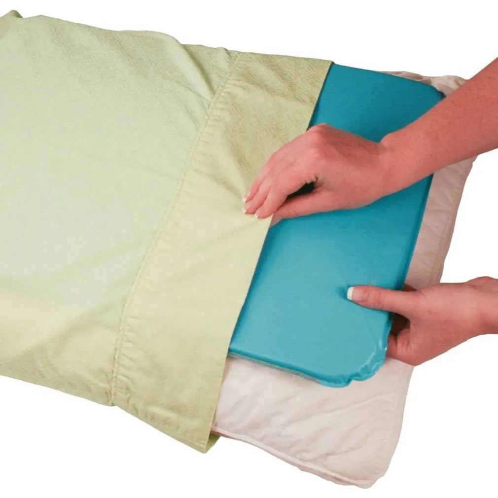 Person holding a blue mat over a beige blanket on a white background