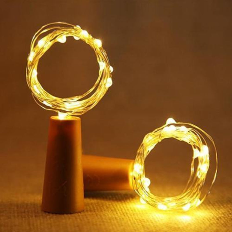 Two string lights on brown stands with a warm glow against a dark background
