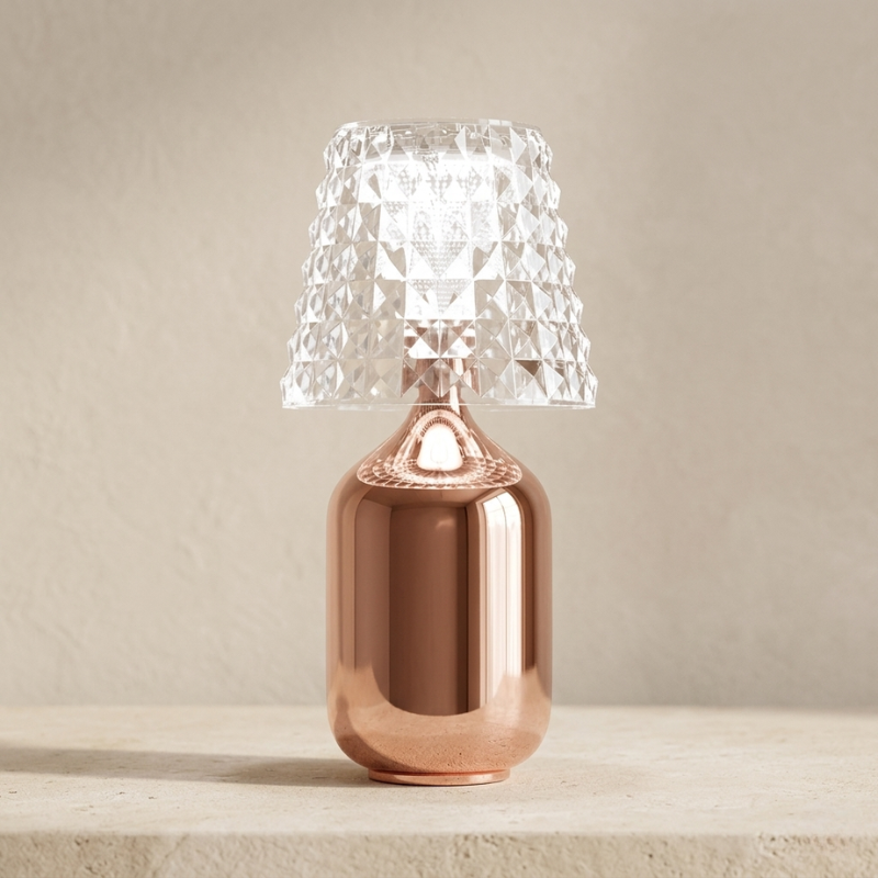 Table lamp with a copper base and clear glass shade on a neutral background