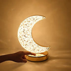 Decorative moon-shaped lamp with floral patterns on a warm beige background