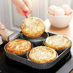 Person using a spatula to lift a pancake out of a four-sectioned pan with eggs in the background.