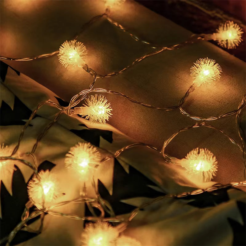 Warm white fairy string lights draped across a brown textured surface, glowing with a soft golden-yellow light.