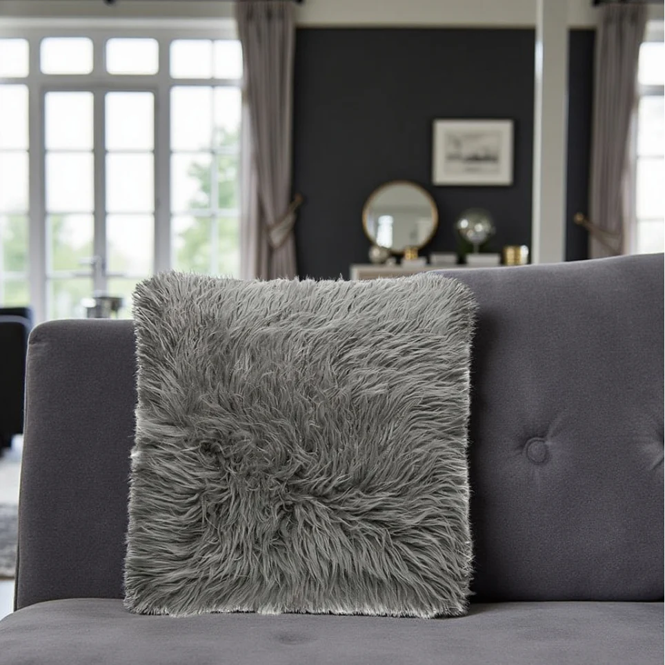 Gray fluffy pillow on a gray sofa in a living room setting.