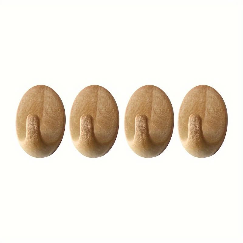 Four wooden wall hooks on a white background