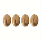 Four wooden wall hooks on a white background