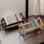 Two wooden book stands with books on a wooden floor.