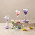 Set of colorful hourglasses on a wooden surface with a beige background