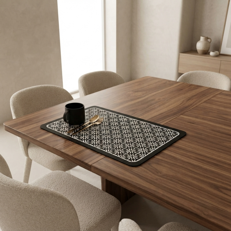 Dining table with a black and white patterned placemat, mug, and spoon in a modern kitchen.