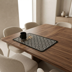 Dining table with a black and white patterned placemat, mug, and spoon in a modern kitchen.