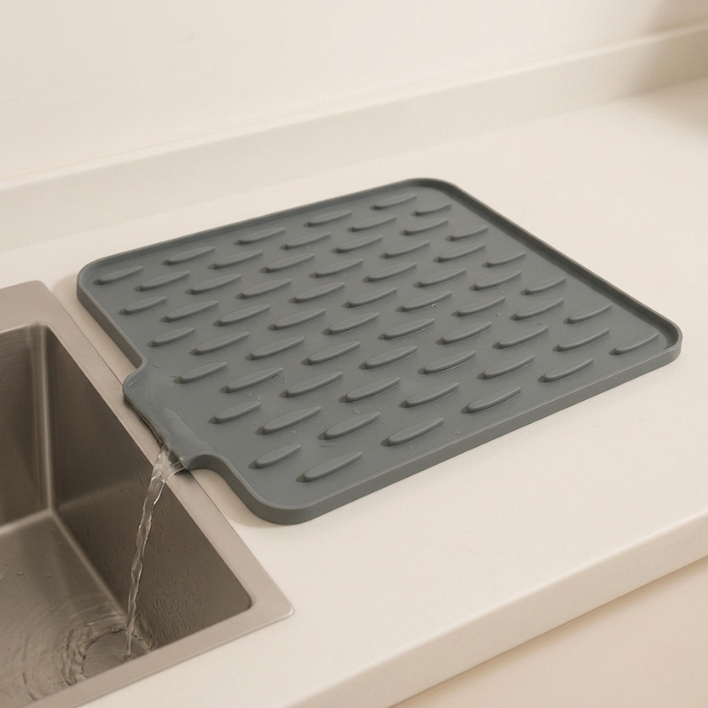 Gray silicone mat on a kitchen counter next to a sink