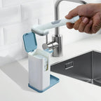 Hand using a cleaning brush with a stand near a sink