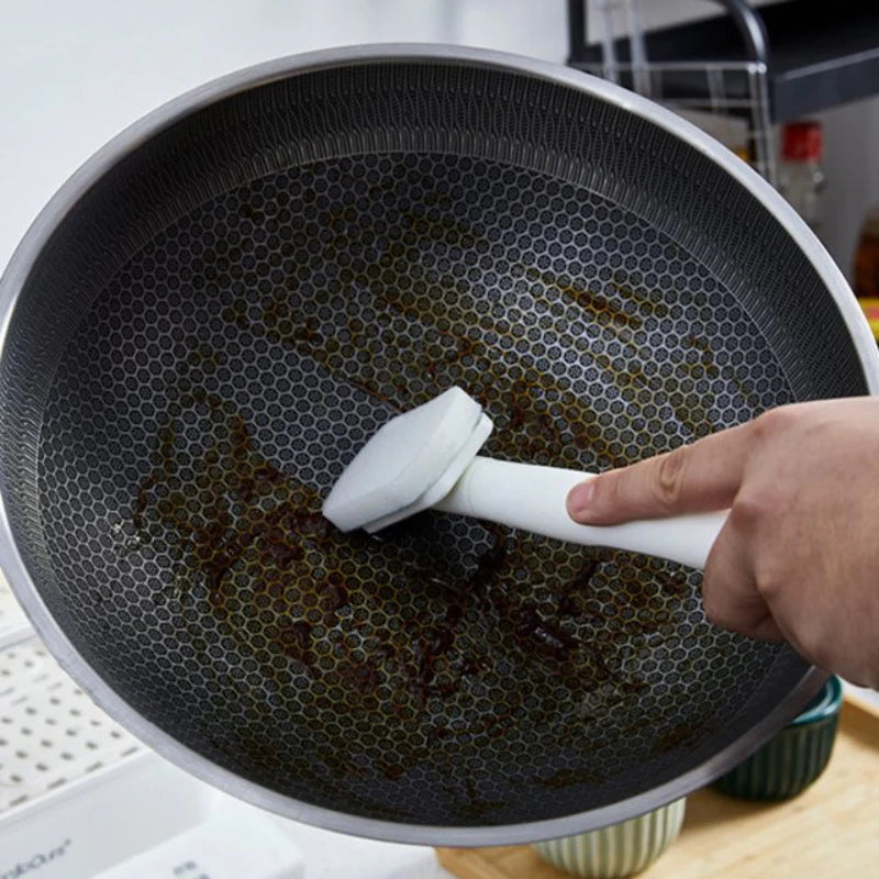 Person scrubbing a non-stick frying pan with a brush
