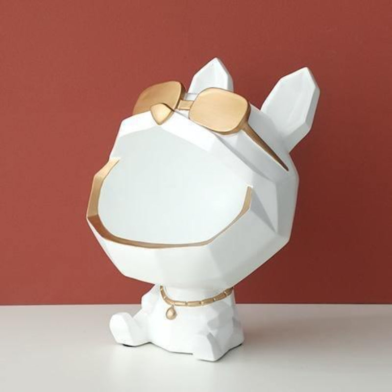 White and gold decorative item resembling a dog with sunglasses on a red background