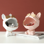 Two dog-shaped decorative items on a surface with a red-brown background