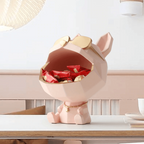 Pink dog-shaped container with red and gold items on a white surface