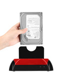 A hand holding a silver Seagate hard drive above a black and red external drive station on a white background.