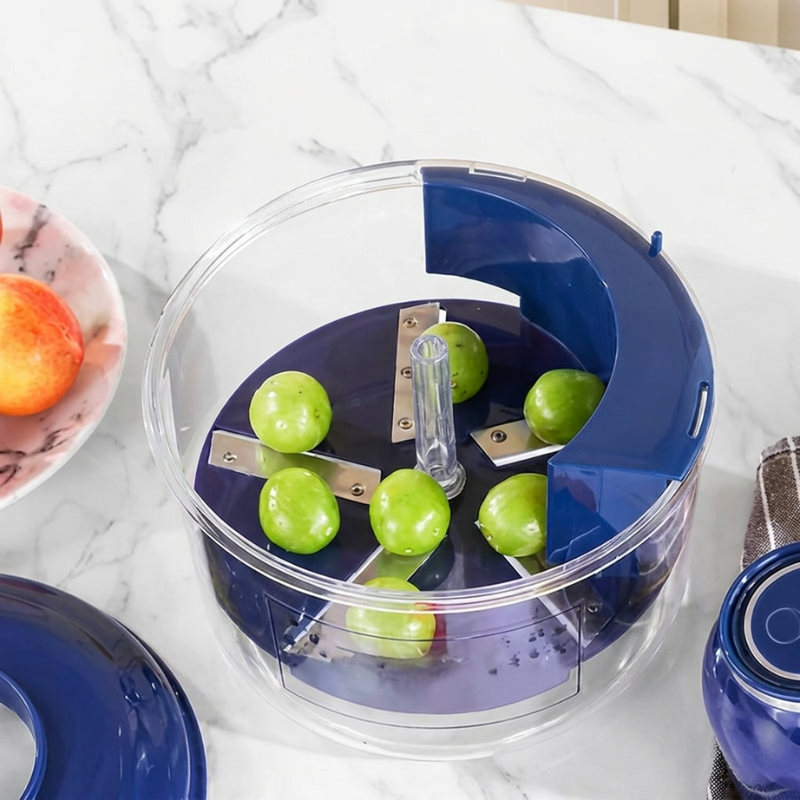 Blue and clear kitchen tool with green apples inside on a marble surface