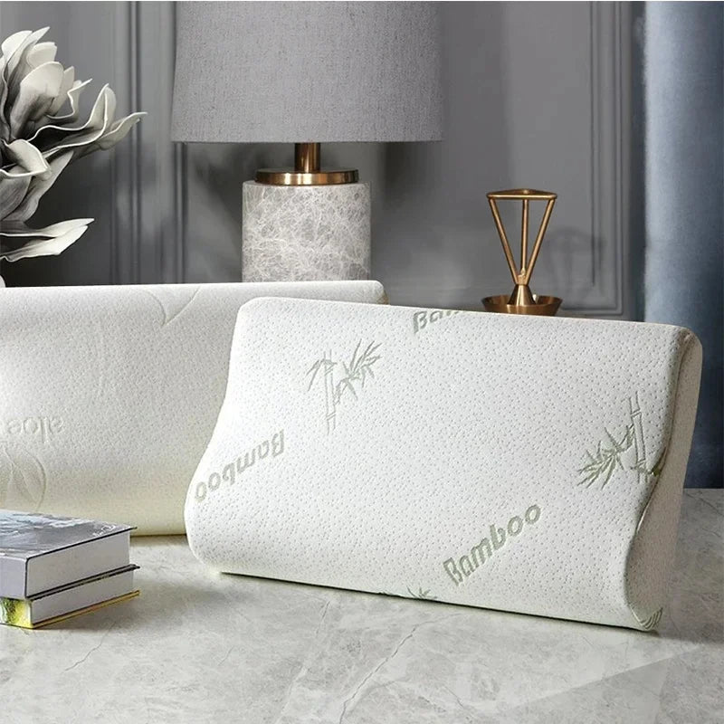 White pillow with bamboo text on a gray surface, with a lamp and books in the background.
