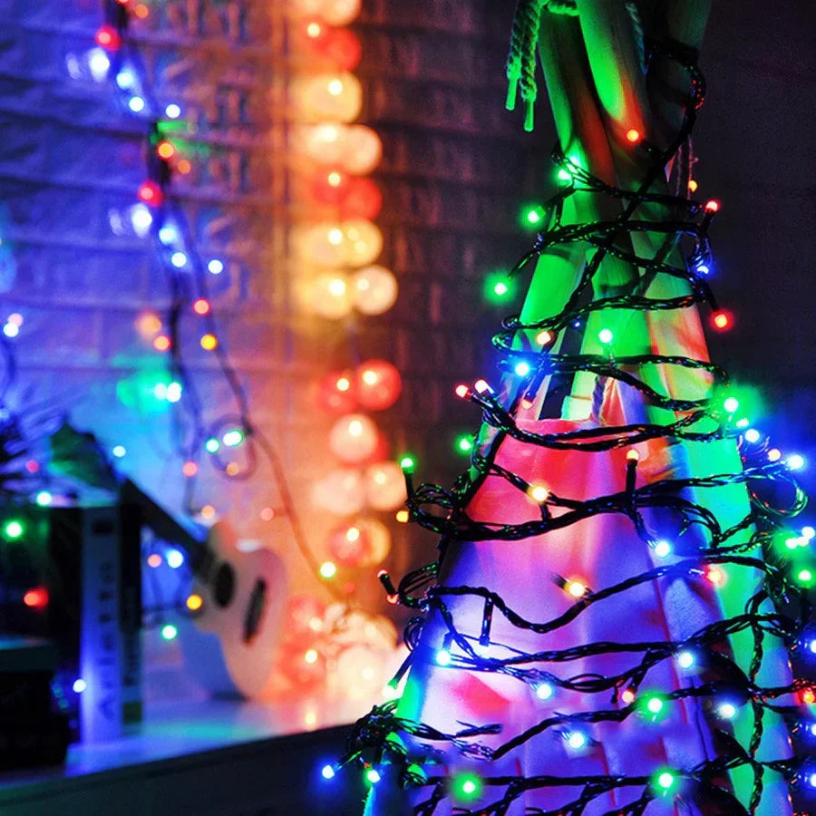 Decorative string lights on a tree with a blurred colorful background