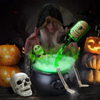 A woman dressed as a witch pours glowing green potion from a green bottle into a bubbling cauldron, surrounded by Halloween props including jack-o'-lanterns, a skull, and skeleton legs in a dark spooky setting.