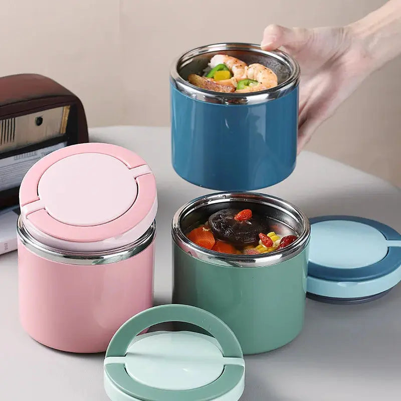 Three colorful stainless steel food containers with lids on a light surface.