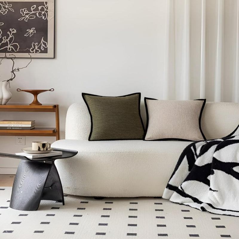 Modern living room with a white sofa, decorative pillows, and a coffee table.