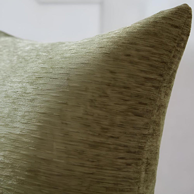 Close-up of a textured throw pillow in a muted olive green color, showing the fabric weave and corner detail.