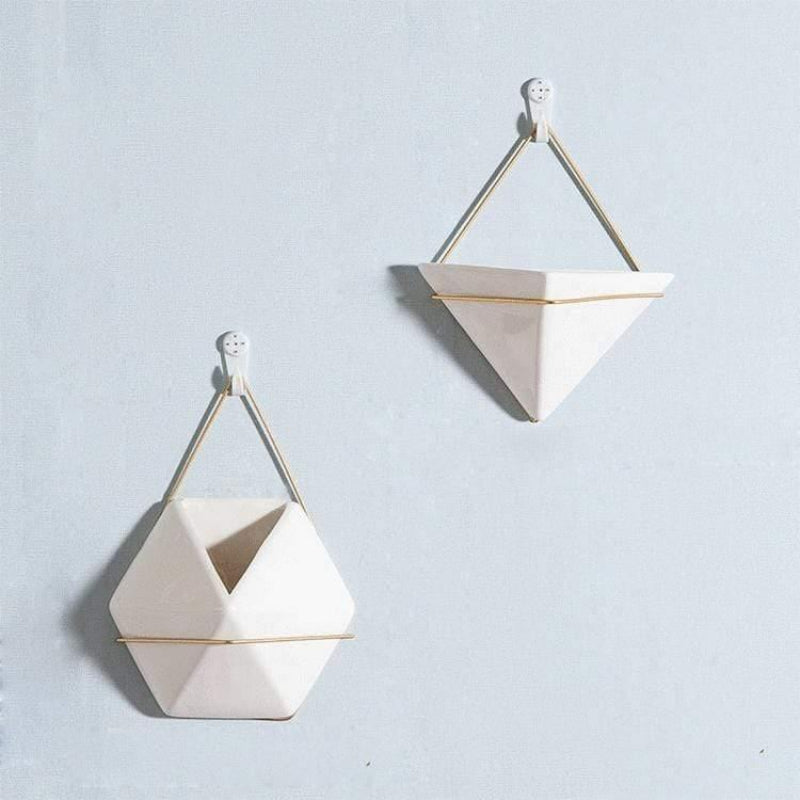 Geometric ceramic wall hanging planters on a light blue background