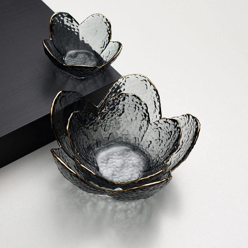 Decorative glass bowls with gold rims on a light gray background