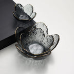 Decorative glass bowls with gold rims on a light gray background
