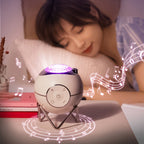 White and purple device emitting music notes on a table with a person lying in bed in the background
