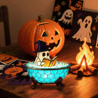 Halloween-themed decoration with a ghost in a bowl, pumpkin, and candles on a wooden surface.