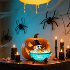 Halloween-themed decoration with a ghost in a bowl, pumpkin, candles, and spiders.