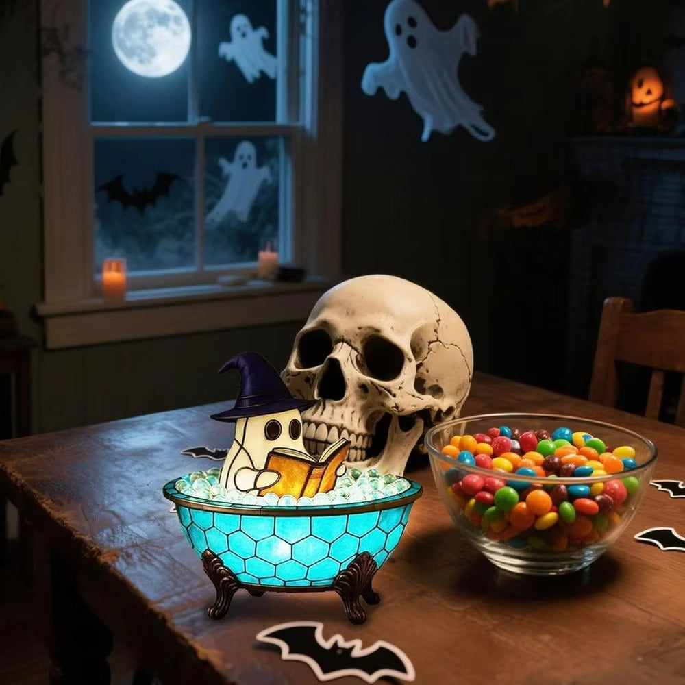 Halloween-themed setting with a skull, ghost, and candy on a table.