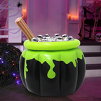 A Halloween-themed inflatable cauldron-shaped candy bucket in black and neon green, filled with silver cans and ice, with a wooden stick prop, set in a decorated purple-toned porch scene.