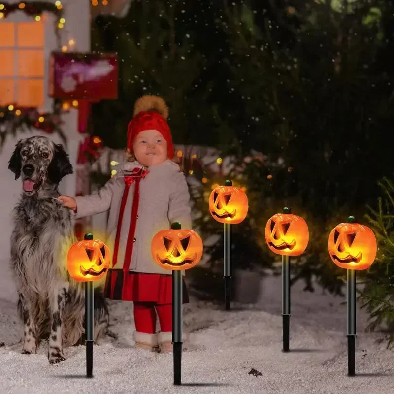 Child and dog with glowing pumpkin lights in a festive outdoor setting