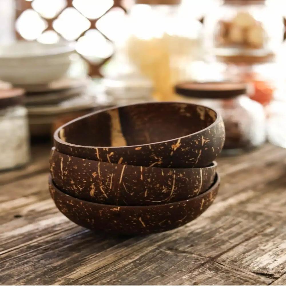 Stack of coconut shell bowls on a wooden surface with a blurred background
