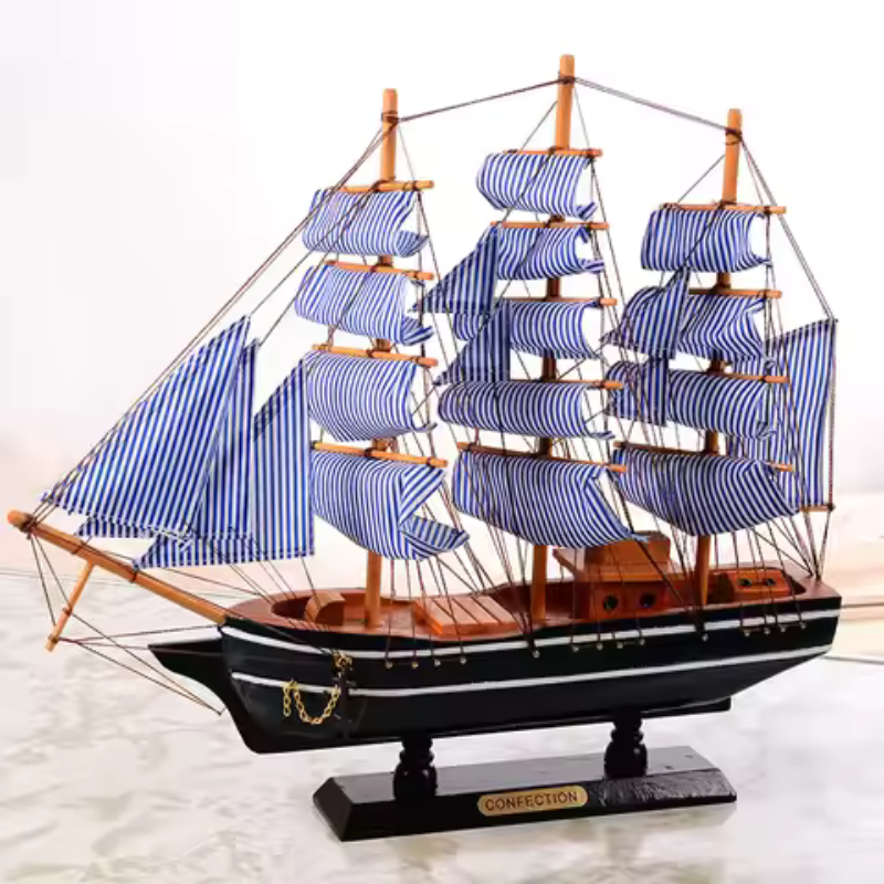 Model ship with blue striped sails on a white background