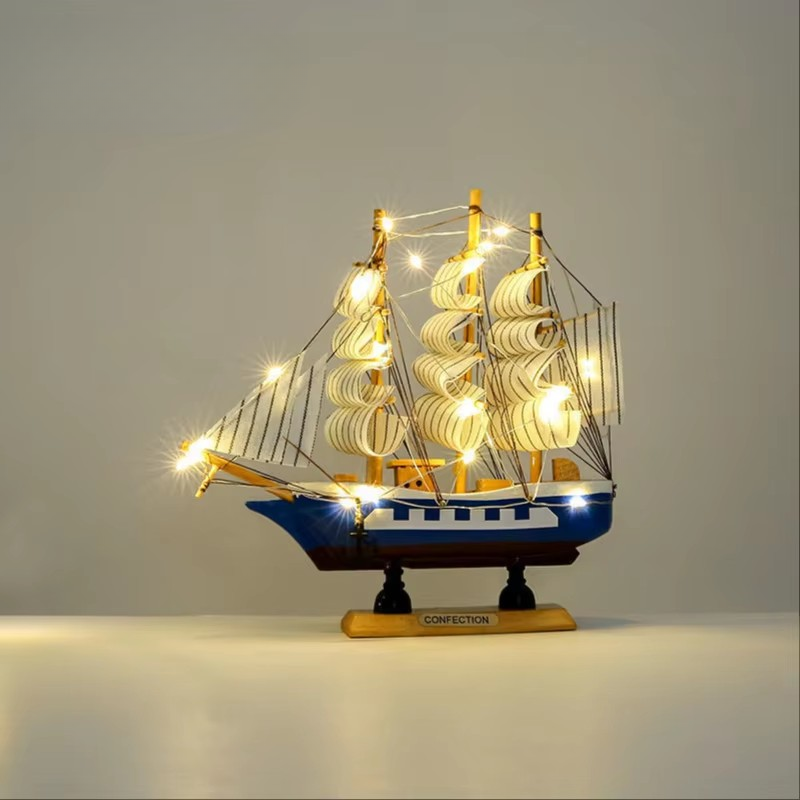 Decorative ship model with lights on a plain background
