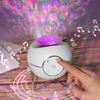 White lamp with purple light on a wooden surface with colorful starry sky projection.