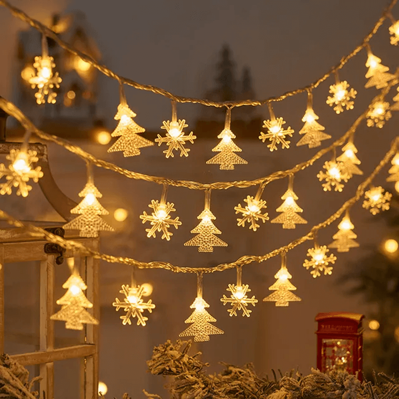 Decorative string lights with Christmas tree and snowflake designs in a festive setting.