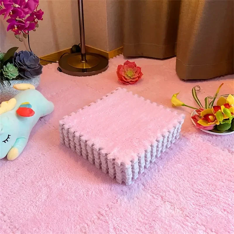 Pink textured box on a pink surface with decorative flowers and a lamp in the background