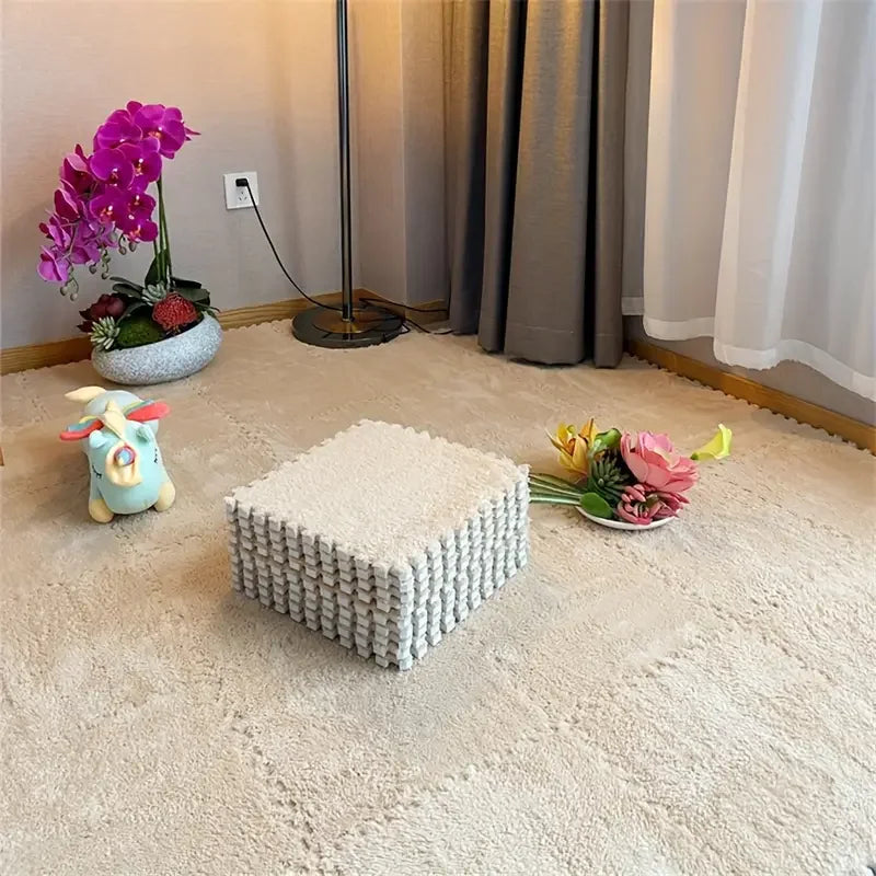 White textured cube on a carpeted floor with decorative items including flowers and a toy.