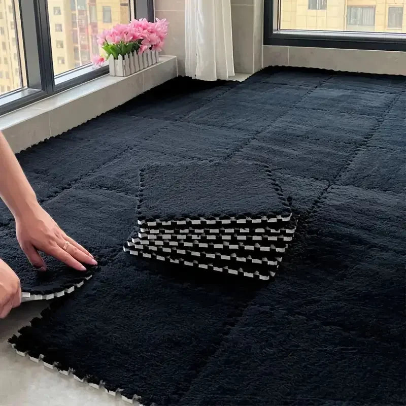 Person arranging interlocking foam mats on a floor with a window and flowers in the background