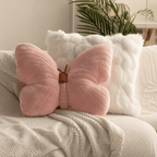 Pink butterfly-shaped pillow on a couch with a neutral background