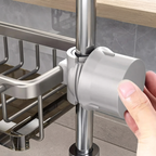 Hand holding a gray kitchen tool under a metal rack