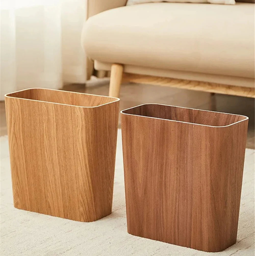 Two wooden wastebaskets on a light-colored carpet with a beige sofa in the background.